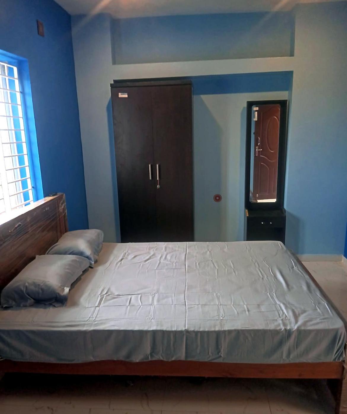 Blue bedroom with a double bed, wardrobe and dressing mirror